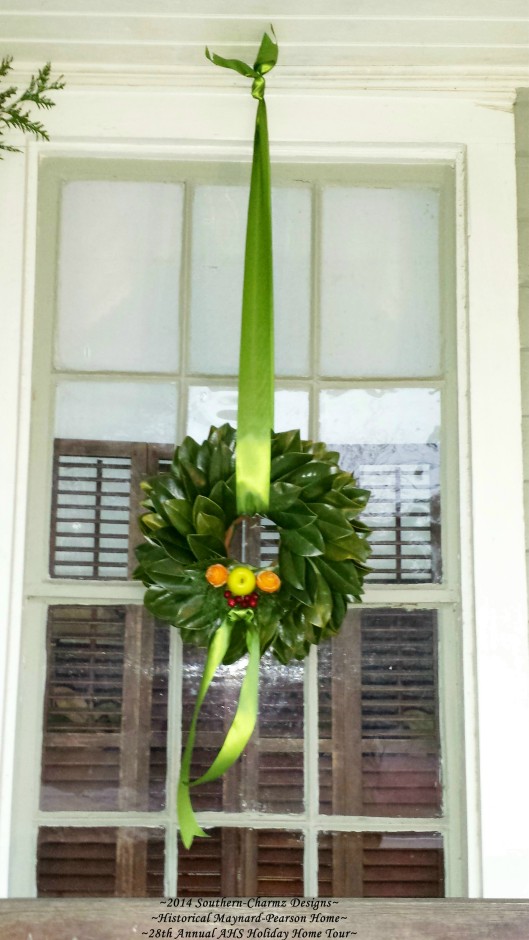 This delicate, but charming fresh magnolia leaf wreath welcomes passers-by with a happy collection of Holiday fruits and foliage. Made of layers of fresh magnolia leaves, this traditional wreath is accented with a green apple and two fresh orange peels fashioned into roses on either side. A trio of fruits used as a welcomed harbinger of the Christmas Holy family.
